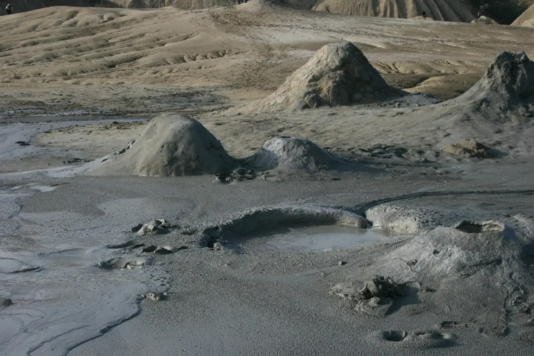 Grey cones and pools of a mud volcano field